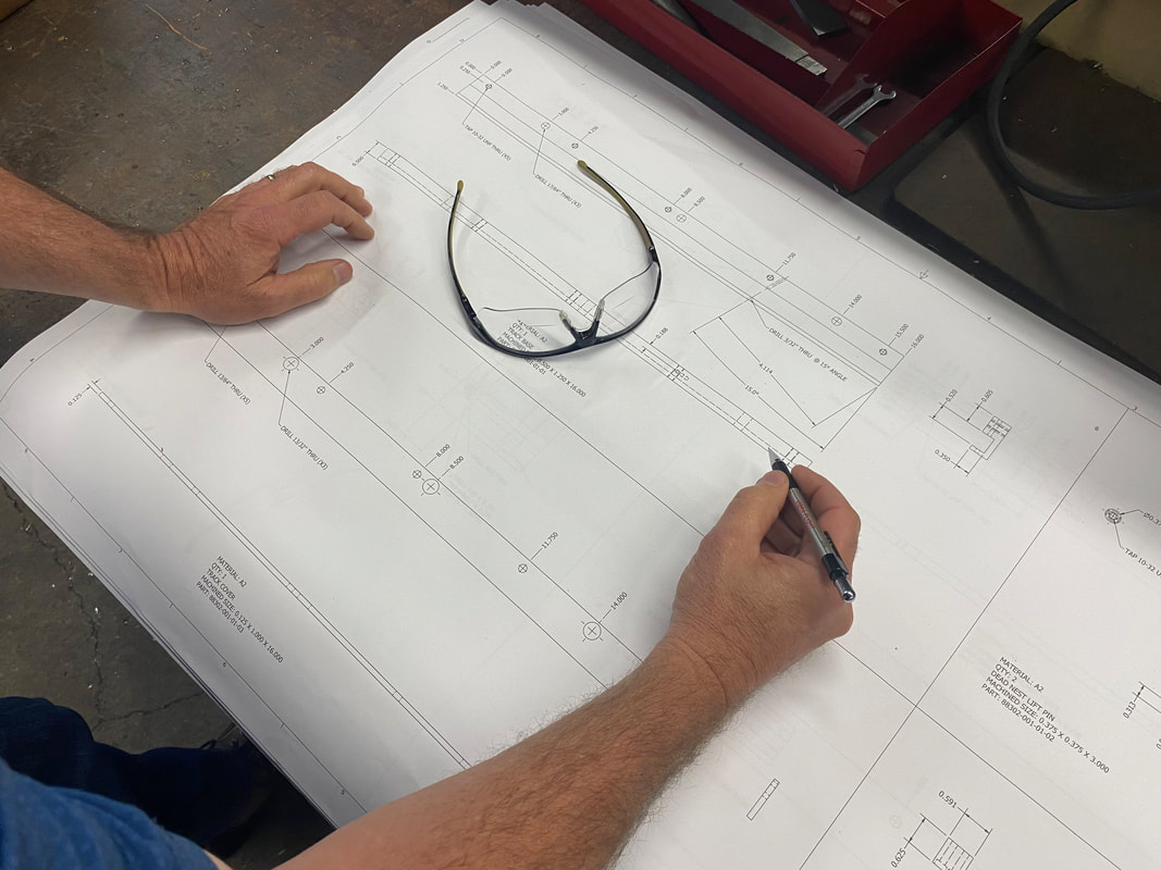 Automation engineer drawing plans for a vibratory bowl build